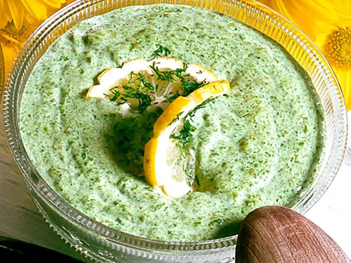 En skål med krämig salsa verde, garnerad med citronskivor och dill. Perfekt till sommarmaten!
