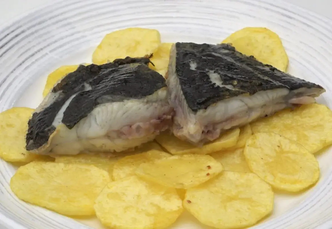 Rodaballo a la plancha servido sobre patatas fritas crujientes. Un plato sencillo y delicioso.