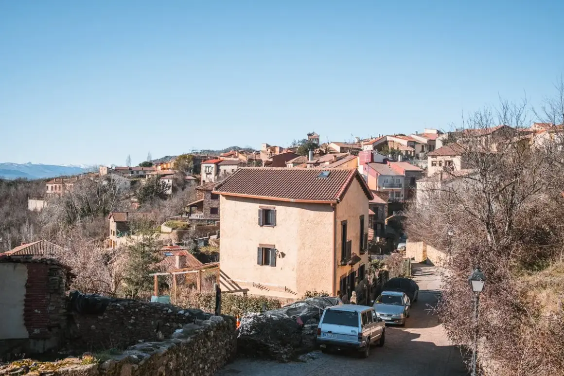 Casas de piedra y tejados rojos en un pueblo de montaña, hogar de los **habitantes Montejo de la Sierra**.
