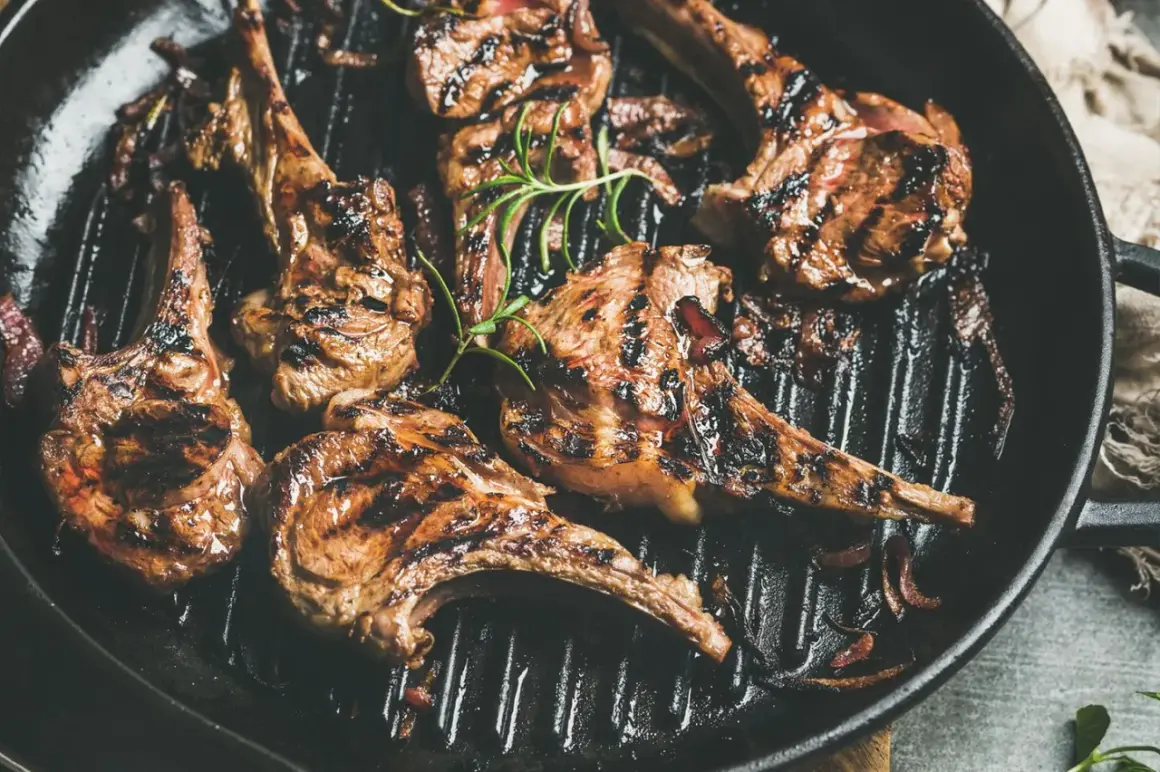 Saftiges Lamm grillen in einer Pfanne mit Rosmarin und Zwiebeln. Perfekt gegrillte Lammkoteletts mit köstlichen Röstaromen.