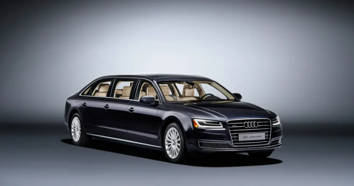 Ciemnogranatowy Audi A8L extended, luksusowa limuzyna z jasnym wnętrzem, prezentuje się elegancko na tle gradientu.