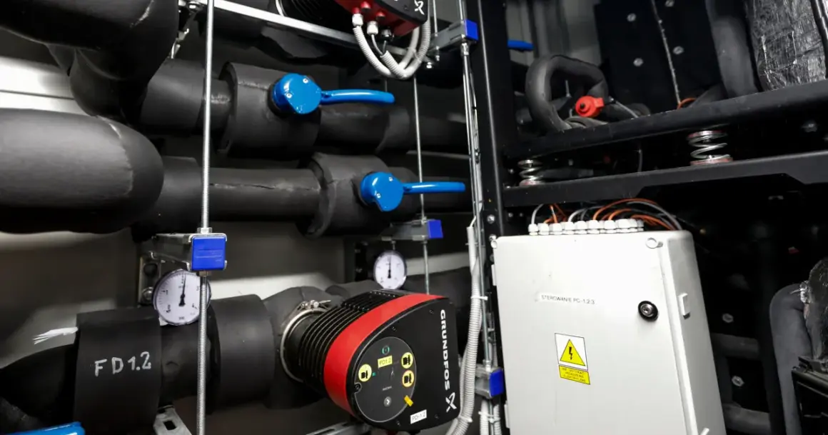 Instalacja grzewcza z pompą Grundfos. Widać rury, zawory i manometry, kluczowe dla efektywności pompy ciepła.