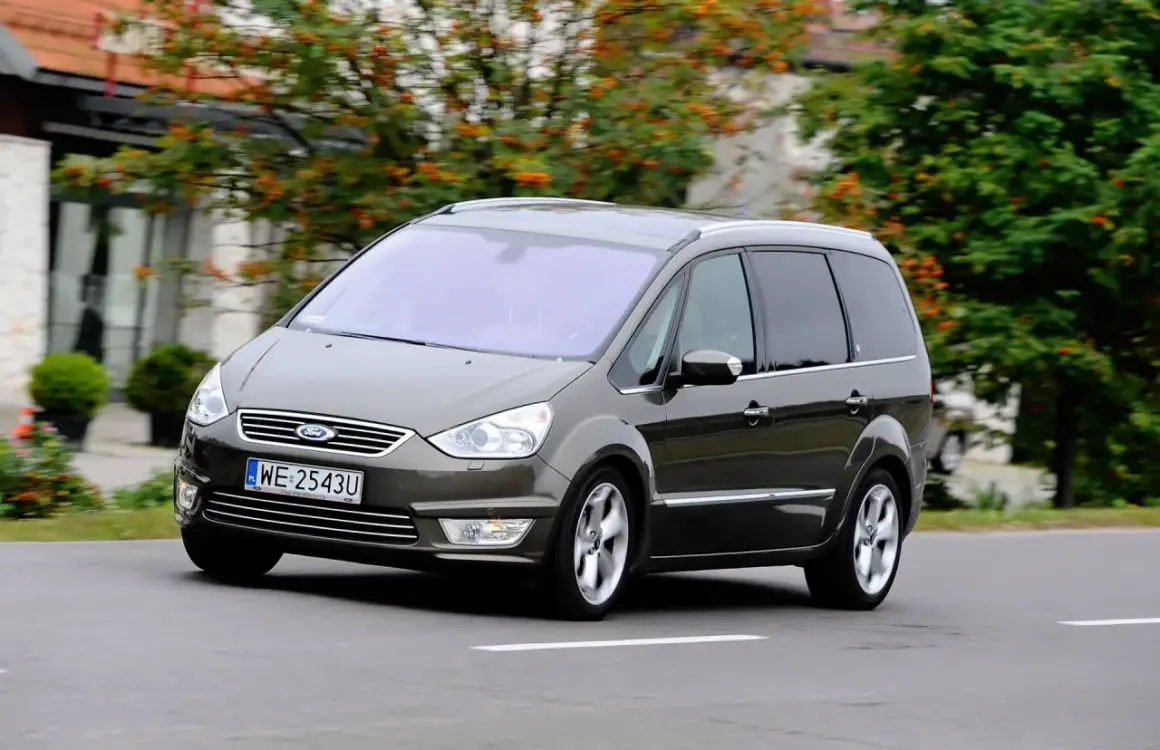 Brązowy Ford Galaxy MK2 w ruchu, z widocznymi felgami i tablicą rejestracyjną WE 2543U.