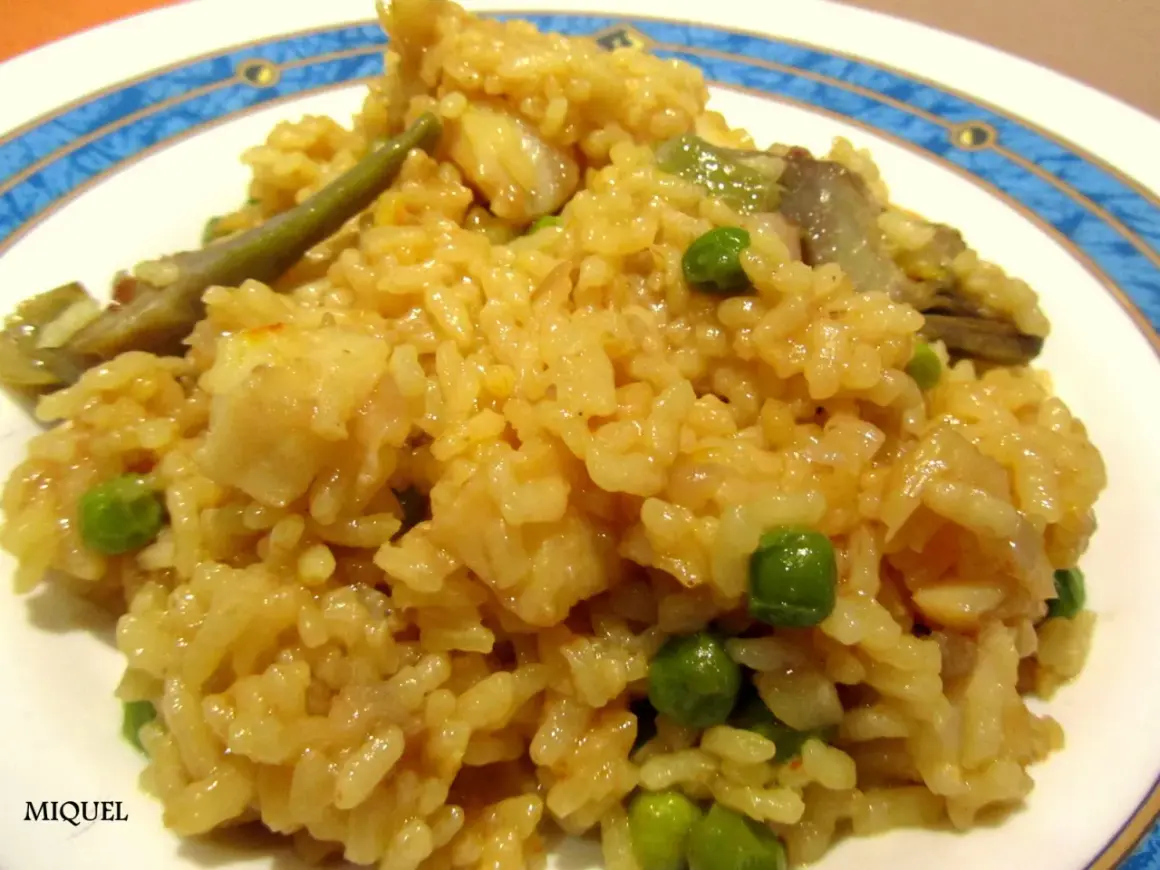 Arroz con bacalao y alcachofas, un plato reconfortante con guisantes verdes y trozos de pescado blanco.