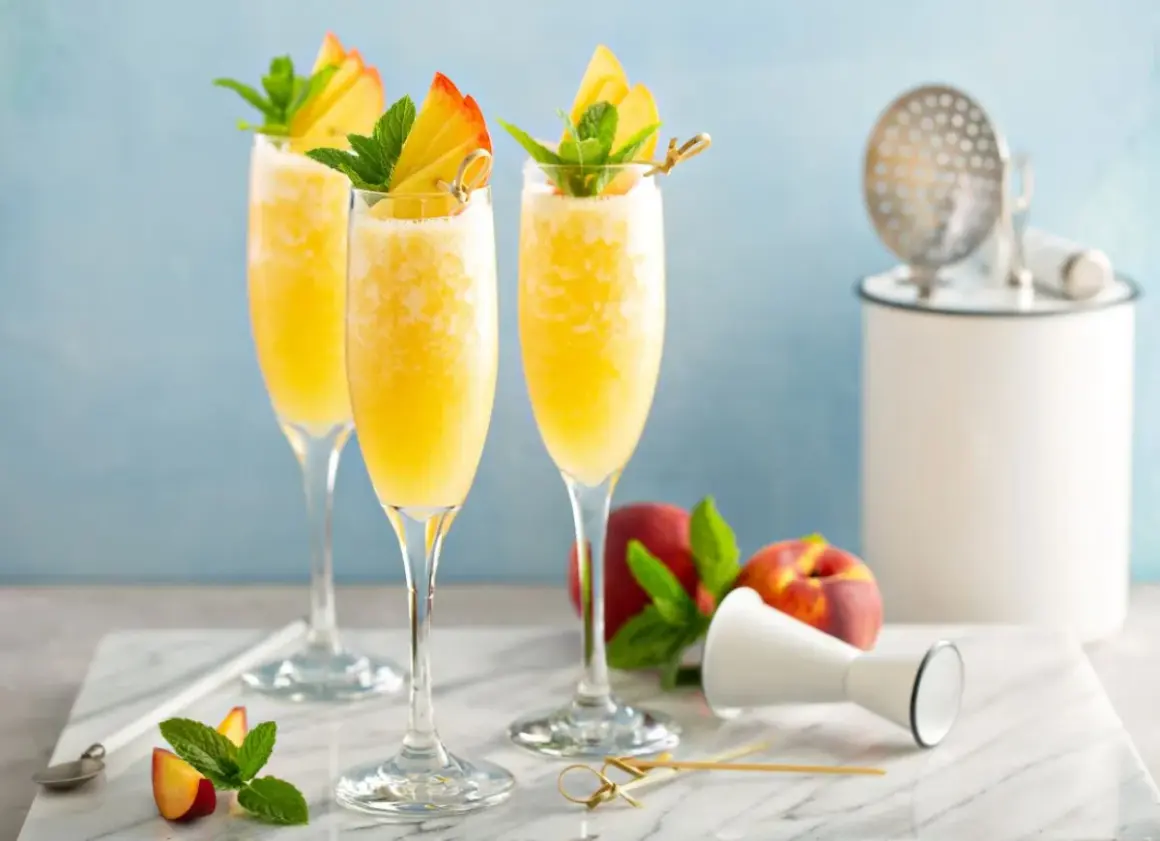 Orzeźwiający mimoza drink z brzoskwinią i miętą, idealny na letnie popołudnie.
