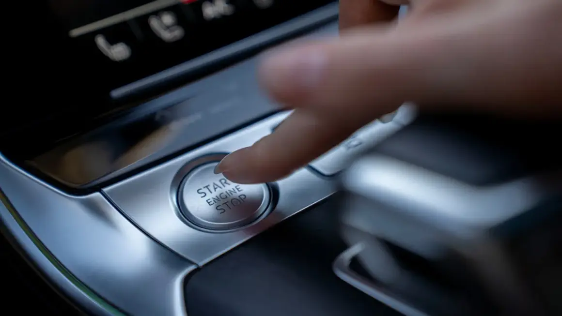 Palec naciska przycisk "START ENGINE STOP", rozpoczynając lub kończąc podróż.