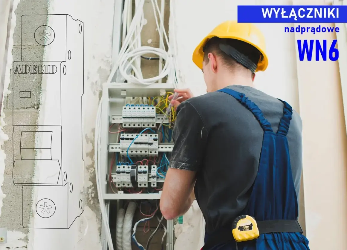 Elektryk w żółtym kasku pracuje przy rozdzielnicy, dokonując doboru zabezpieczeń nadprądowych. WN6.