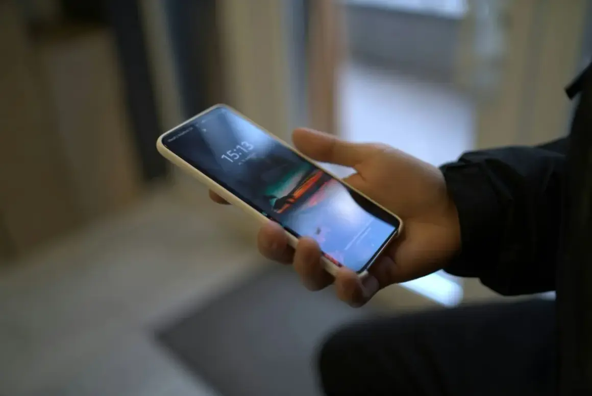 Dłoń trzyma smartfon Samsung. Chcesz wiedzieć, jak wyłączyć dźwięk klawiatury Samsung?