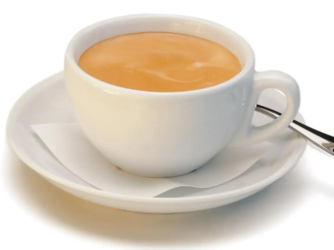 Ein kleiner brauner Kaffee mit Milchschaum in einer weißen Tasse auf einer Untertasse.