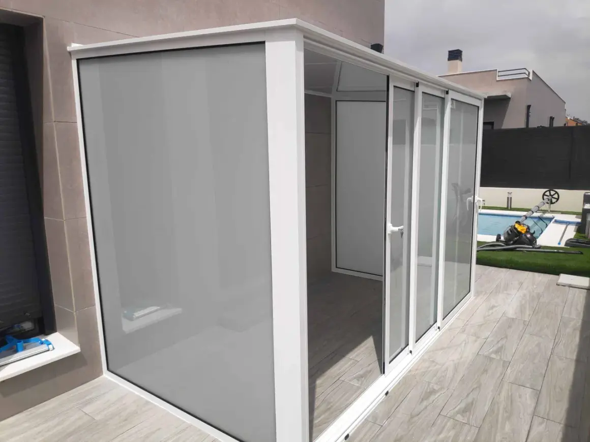 Moderno cierre para balcones y terrazas con puertas correderas de cristal y panel opaco.