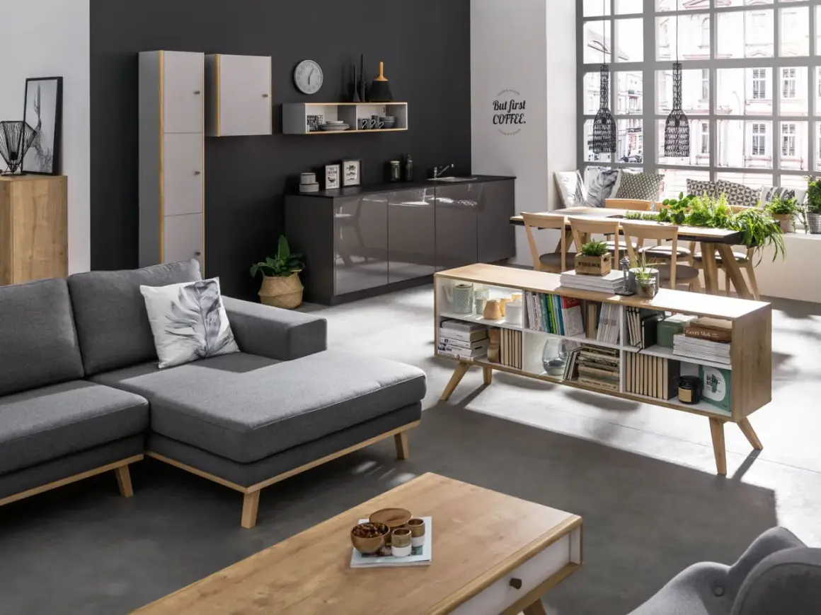Nowoczesny salon z szarą kanapą i ciemną ścianą. Inspiracje na kolory ścian do salonu: grafit, biel, drewno.