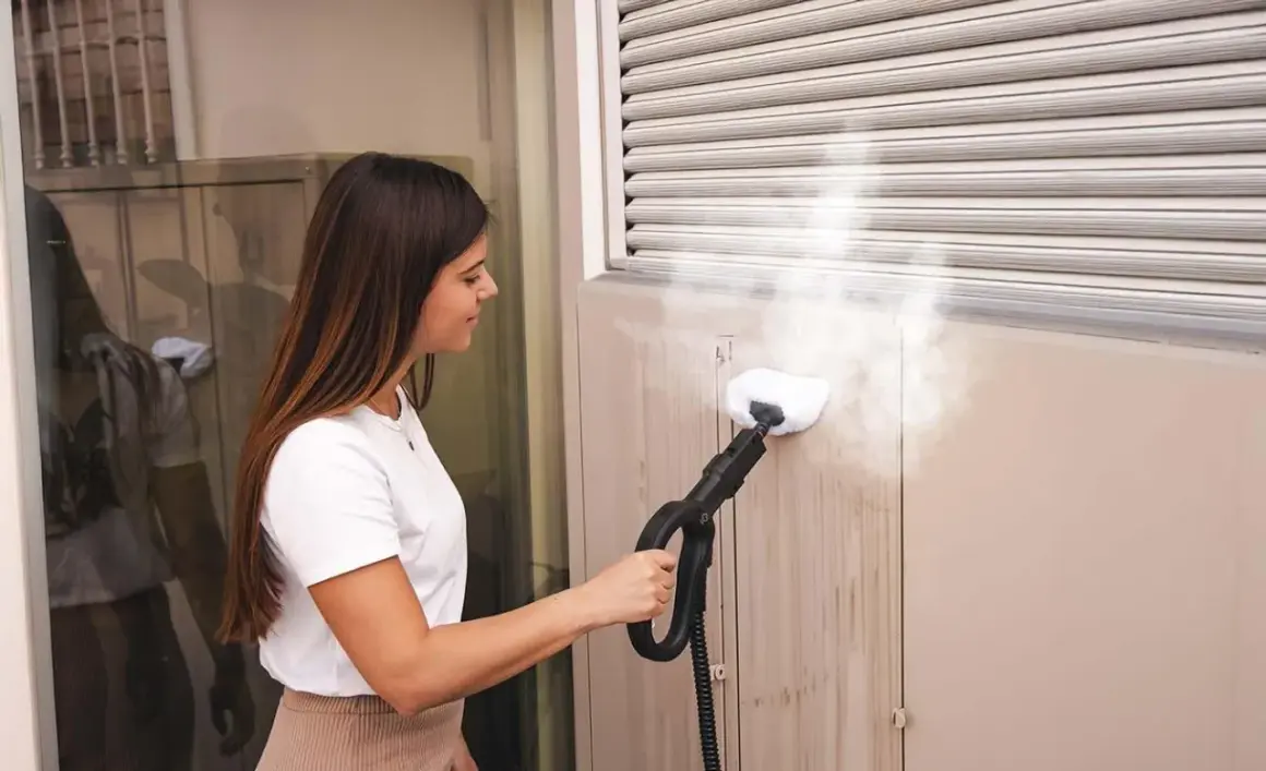 Donna pulisce le tapparelle con un pulitore a vapore, rimuovendo lo sporco in modo efficace.
