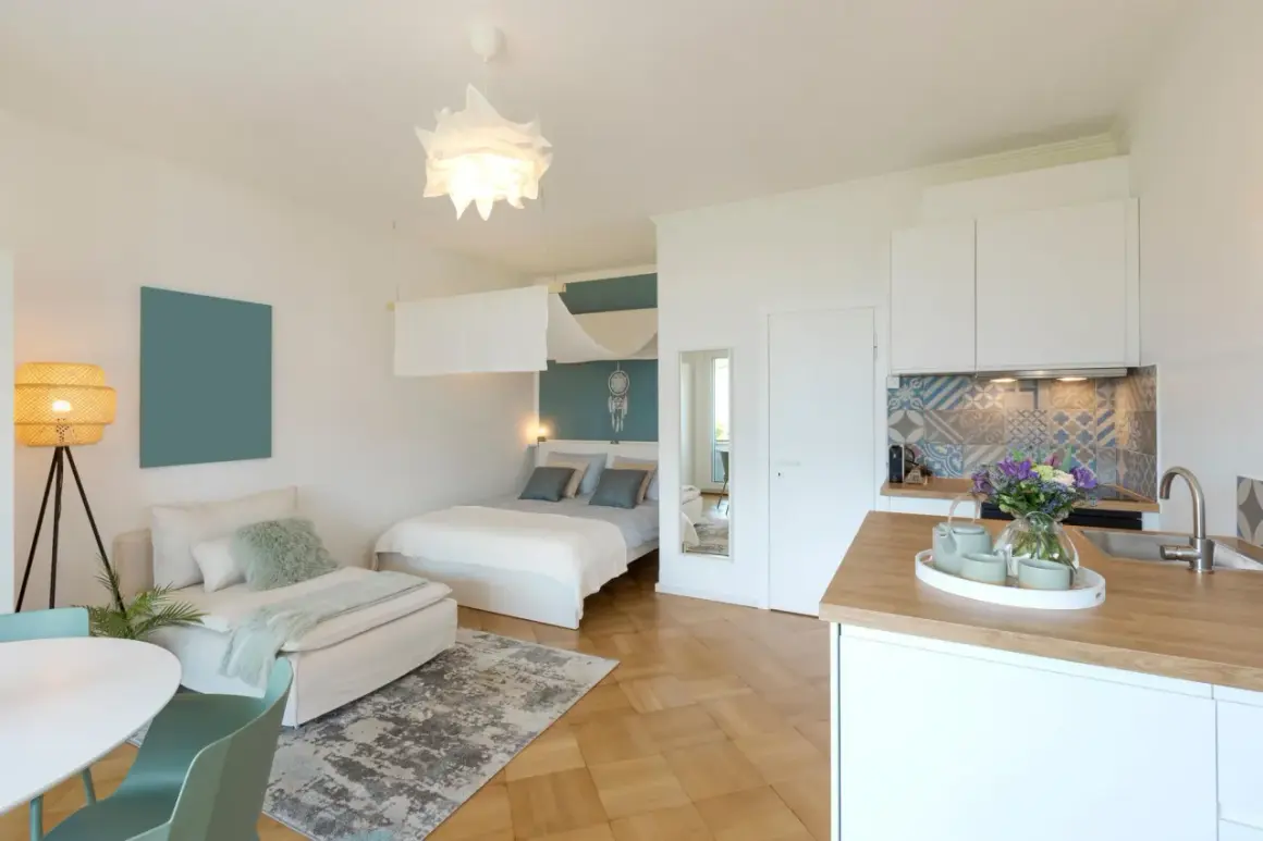 Gemütliche 1 Zimmer Wohnung einrichten 30qm: Bett, Sofa, Küche und Esstisch sind stilvoll integriert.