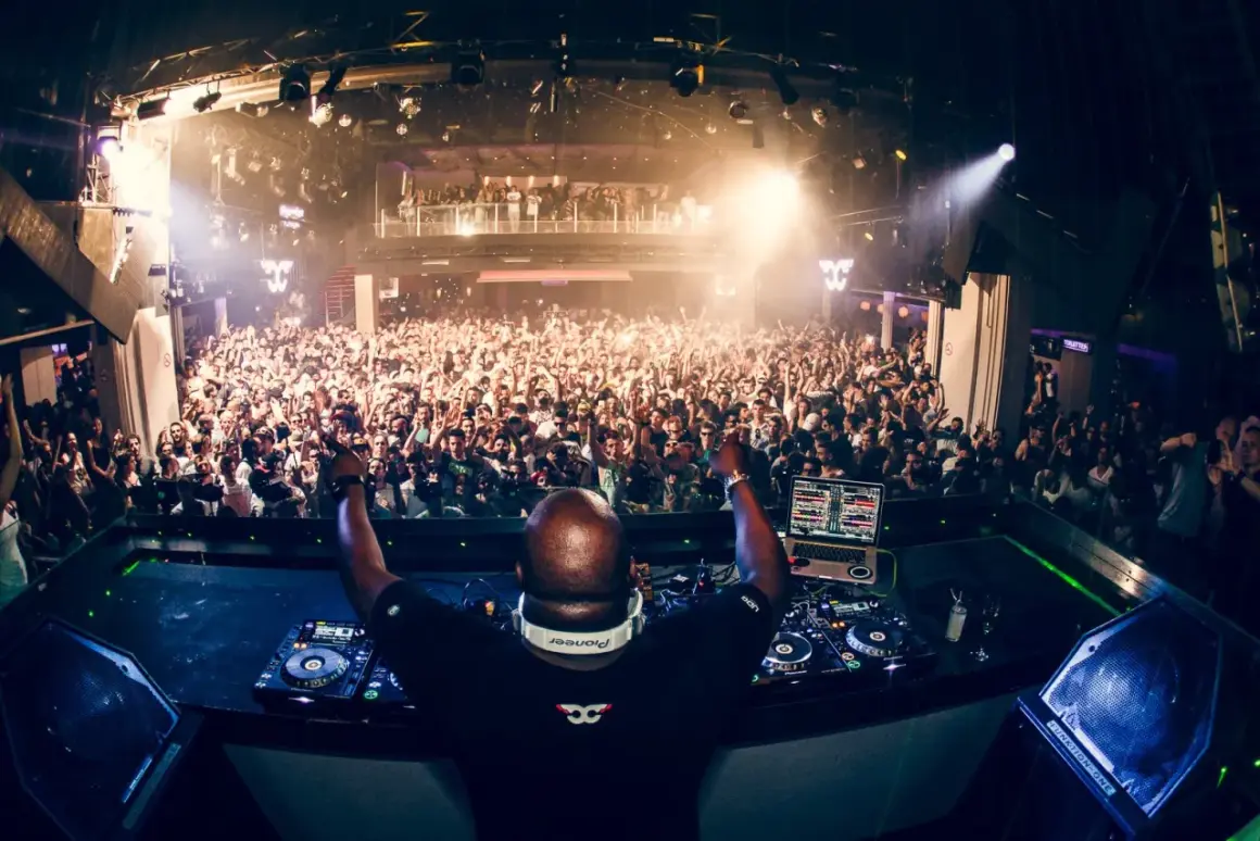 DJ Monika Kruse fa ballare una folla immensa in un club pieno di luci e musica.