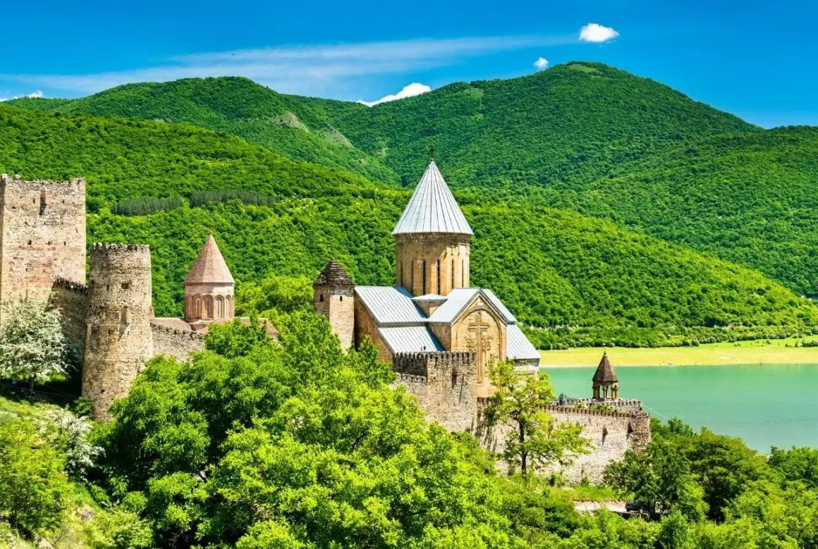 Twierdza Ananuri, kamienny zamek z kościołami, wznosi się na tle zielonych gór i turkusowego jeziora.