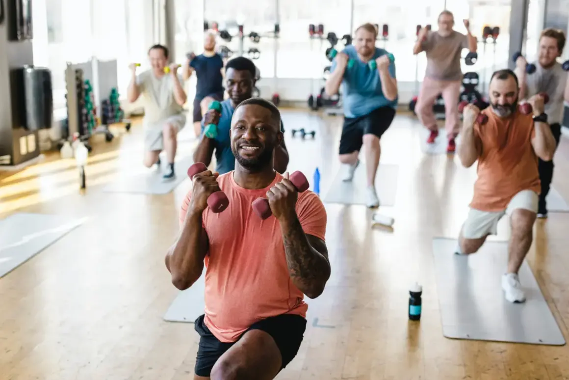 Männer trainieren mit Hanteln im Fitnessstudio. Ob es reicht, eine Muskelgruppe einmal pro Woche zu trainieren, ist eine Frage der Ziele.
