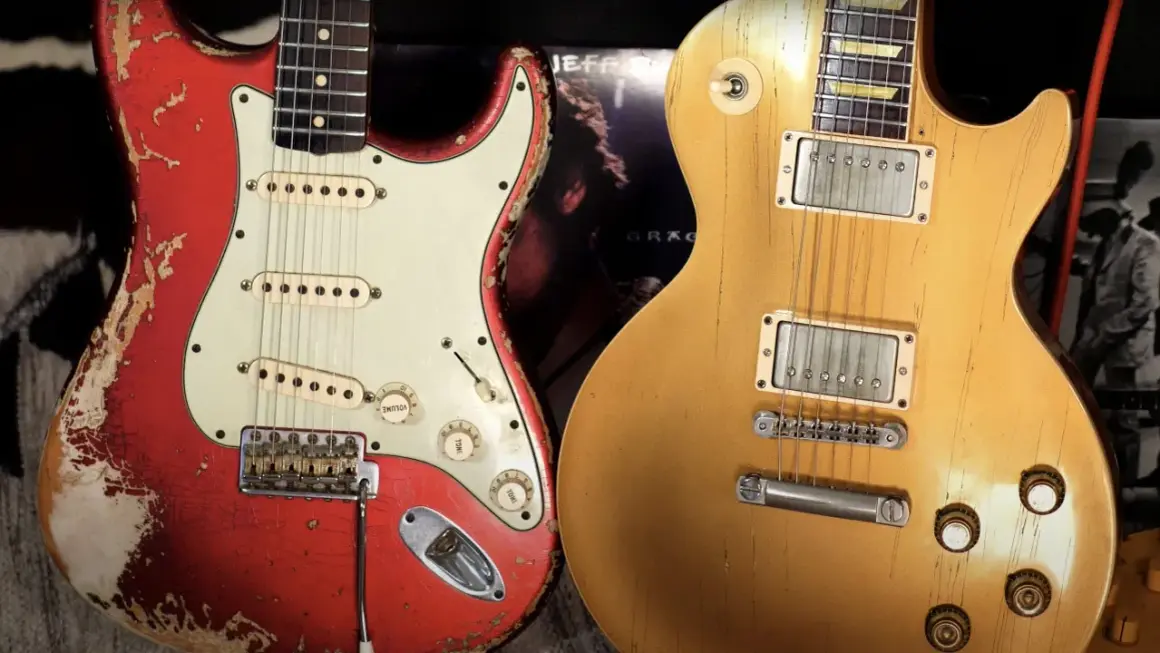 Iconiche chitarre: una Fender rossa consumata e una Gibson dorata, pronte per un duello musicale.