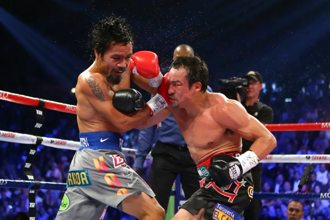 Manny Pacquiao lands a punch on Juan Manuel Marquez during their intense boxing match. Sweat flies as the crowd roars.
