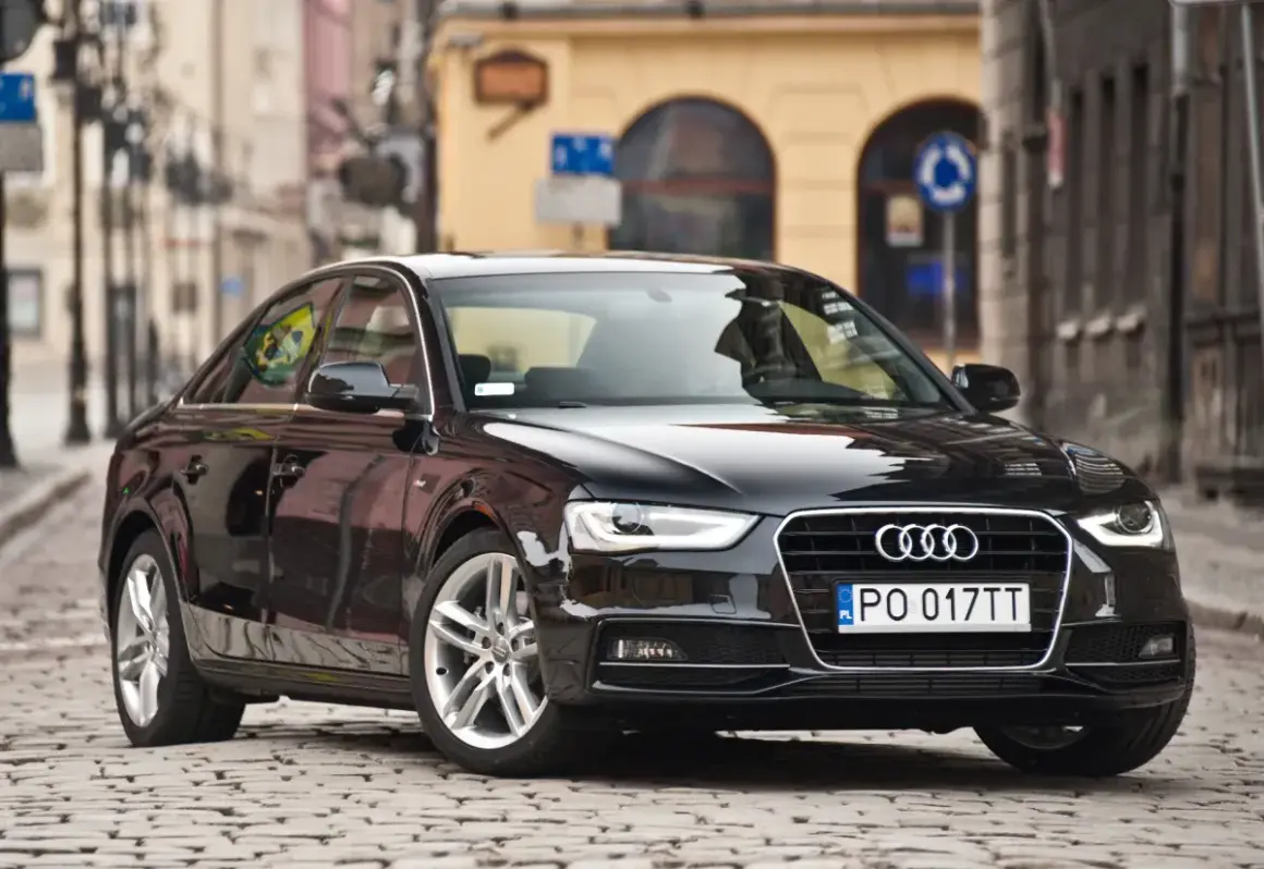 Błyszczący czarny Audi A4 b8 na brukowanej ulicy.