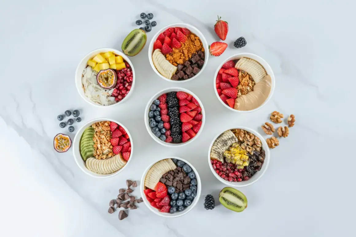 Sju skålar med färgglada frukter, granola och nötter. Perfekta för nyttiga snacks recept som ger energi.