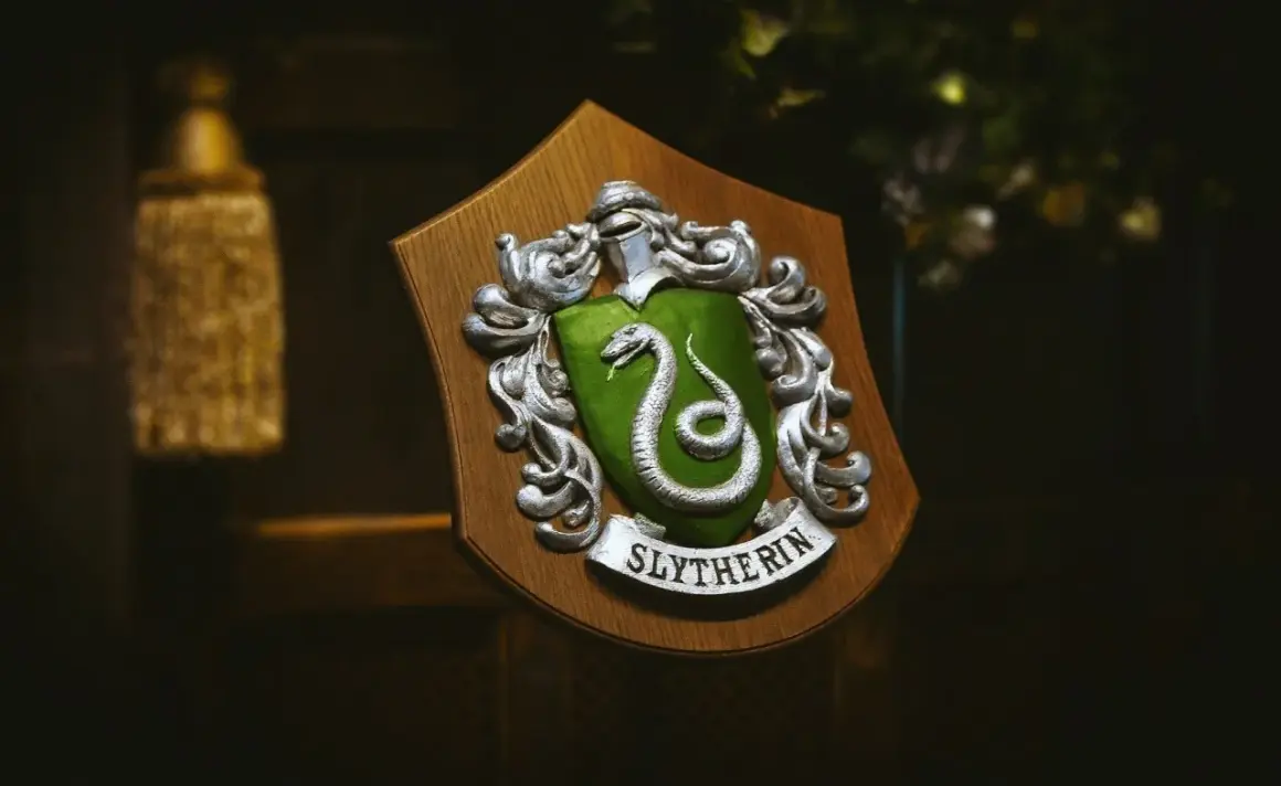 Herb Hogwartu, herb Slytherinu z zieloną tarczą i srebrnym wężem, dumnie prezentuje swoje barwy.