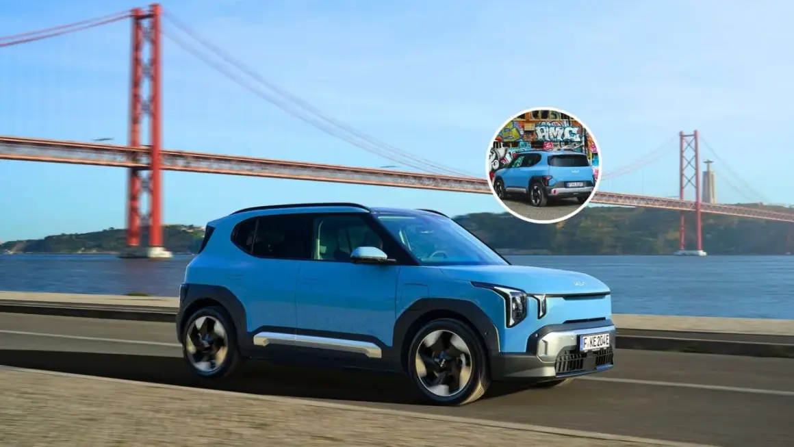 El ev2 Kia azul, con un diseño moderno, cruza un puente icónico. En un círculo, se ve su parte trasera con grafitis.