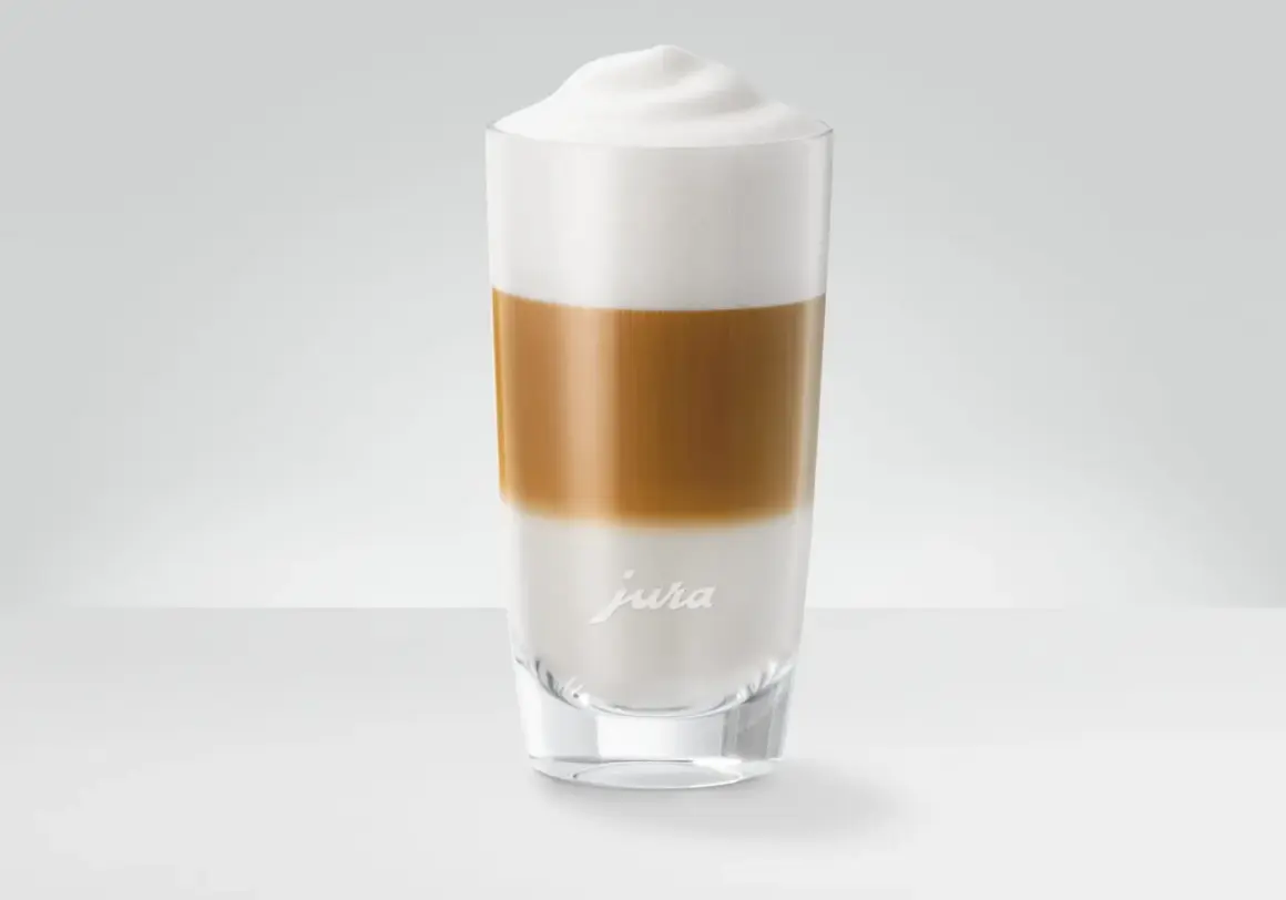 En hög latte macchiato med lager av mjölk och kaffe, toppad med ett fluffigt skum.