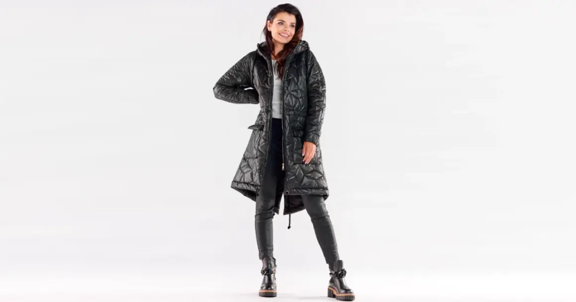 Uśmiechnięta kobieta w czarnej, pikowanej kurtce przejściowej damskiej duże rozmiary. Stylowy look na co dzień.