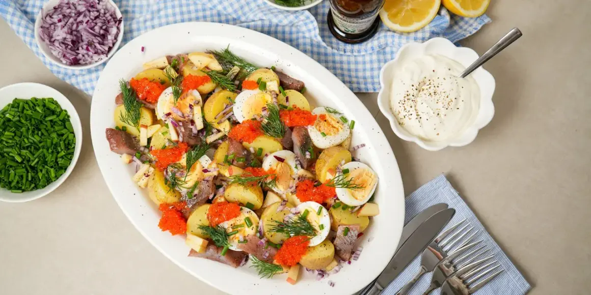 En härlig matjessill sallad med potatis, ägg, rödlök, äpple och rom. Perfekt för ett svenskt midsommarfirande eller sommarbuffé.