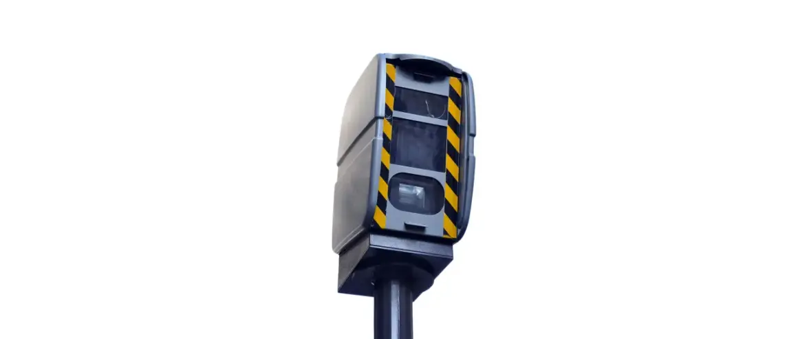 Boîtier gris avec bandes noires et jaunes, monté sur un poteau. Ce radar de contrôle de vitesse est un modèle différent de ceux que l'on voit habituellement.
