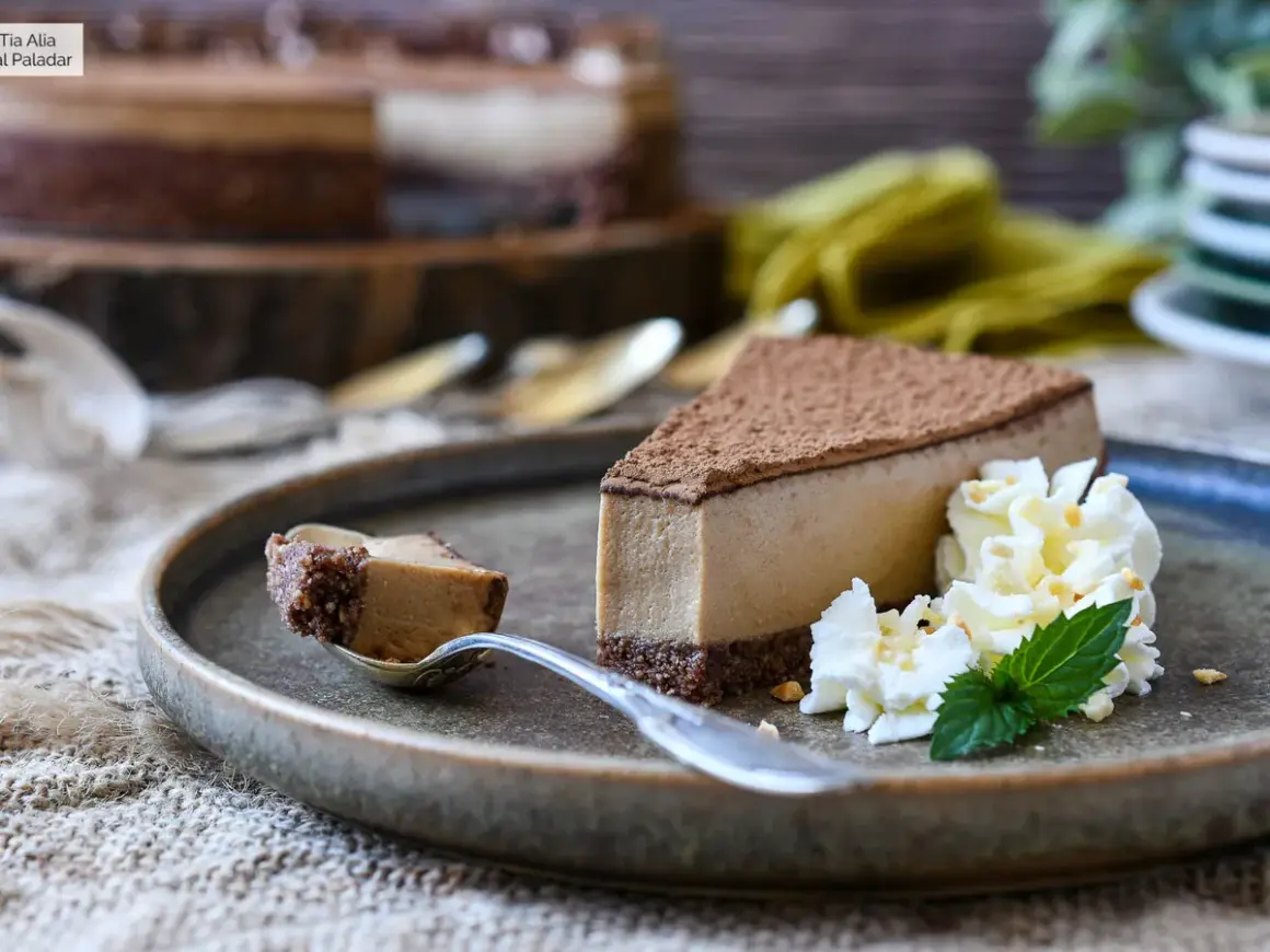 Deliciosa tarta de café con queso Philadelphia, cubierta de cacao y acompañada de nata montada y menta.