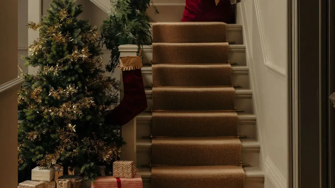 Festlich geschmückter Tannenbaum mit goldenen Zweigen und Geschenken. Die Frage "wann tannenbaum aufstellen" wird hier mit vorweihnachtlicher Deko beantwortet.
