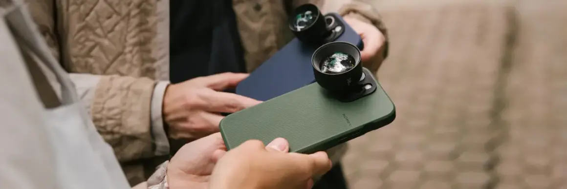 Twee personen houden iPhones vast met externe lenzen, klaar om te fotograferen met hun iPhone.