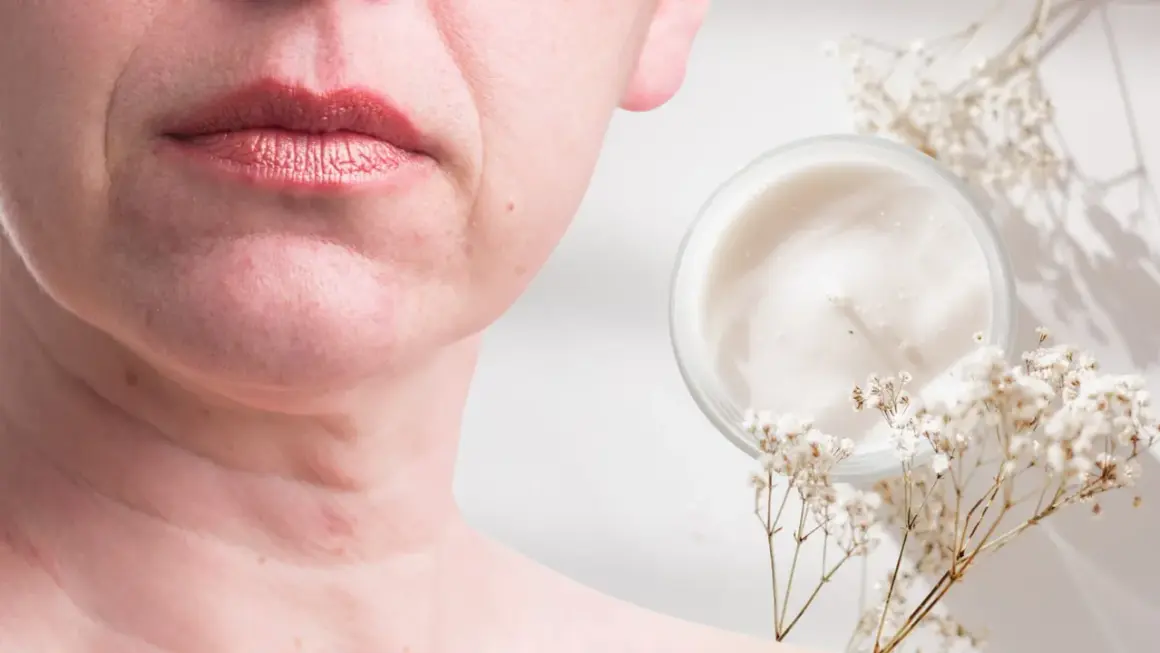 Un vasetto di crema e fiori secchi accanto al viso di una donna, suggerendo come migliorare la pelle del viso con prodotti naturali.