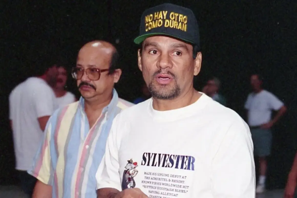 Roberto Duran reach, wearing a cap that says "No Hay Otro Como Duran." He's in a white t-shirt with "Sylvester" printed on it.