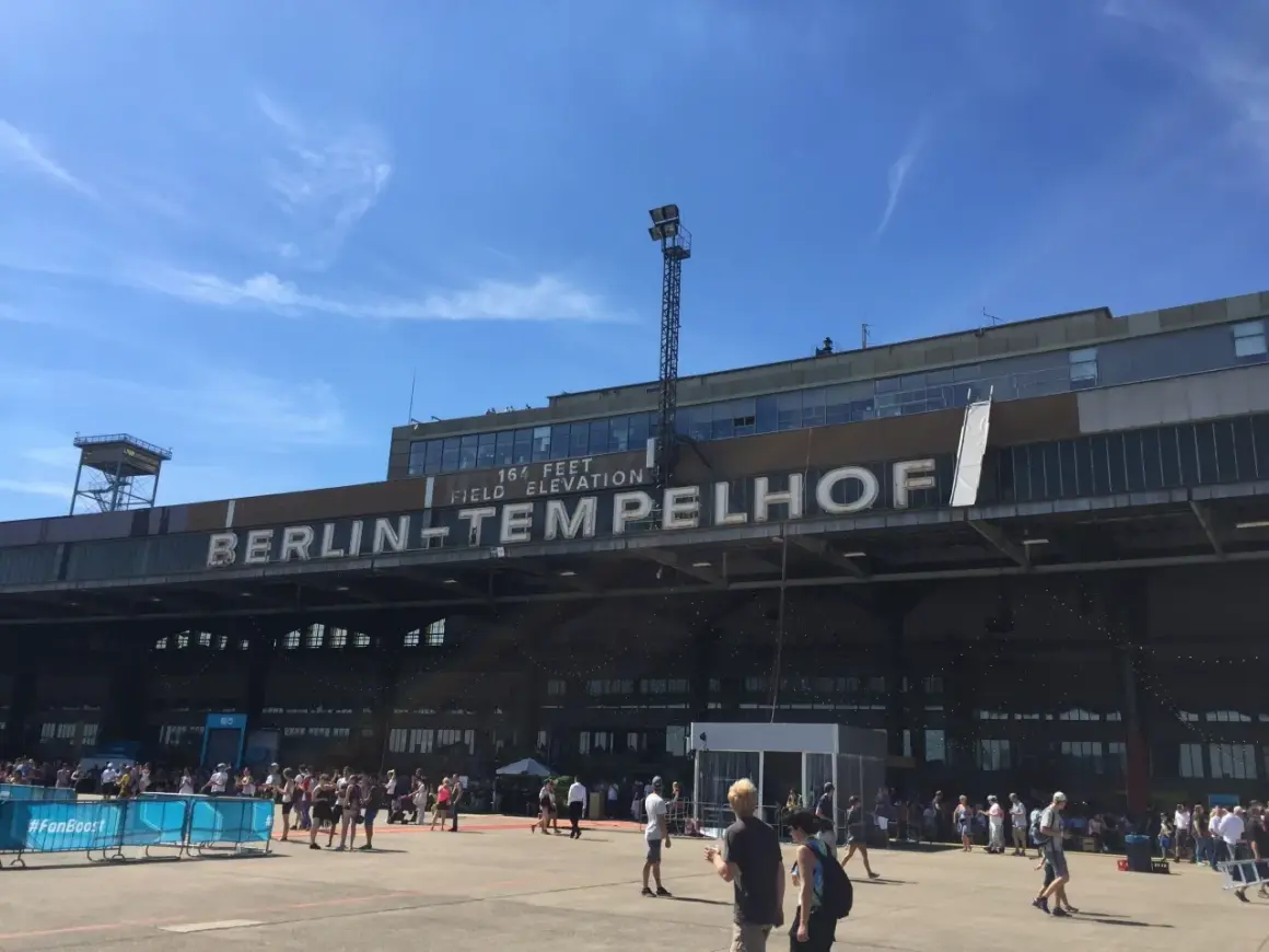 Människor samlas framför den ikoniska byggnaden för Berlins gamla flygplats, Tempelhof.