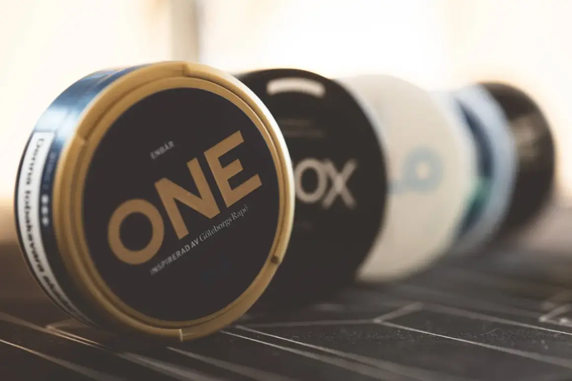 En dosa ONE, inspirerad av Göteborgs Rapé, en av sveriges mest sålda snus. Flera dosor i bakgrunden.