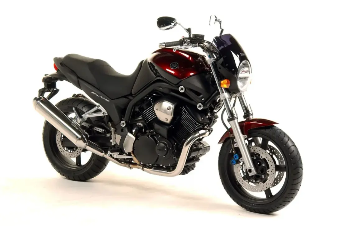 Yamaha Bulldog 1100 ficha técnica: moto naked color burdeos, con motor bicilíndrico en V, asiento negro y escape cromado.