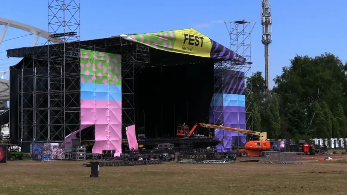 Scena festiwalowa w trakcie przygotowań. Kolorowe banery i konstrukcje zapowiadają nadchodzący fest.