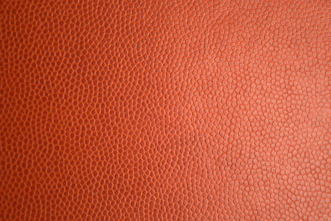 Texture d'un ballon de basket orange. Pour savoir si c'est du vrai cuir, observez la régularité des alvéoles.