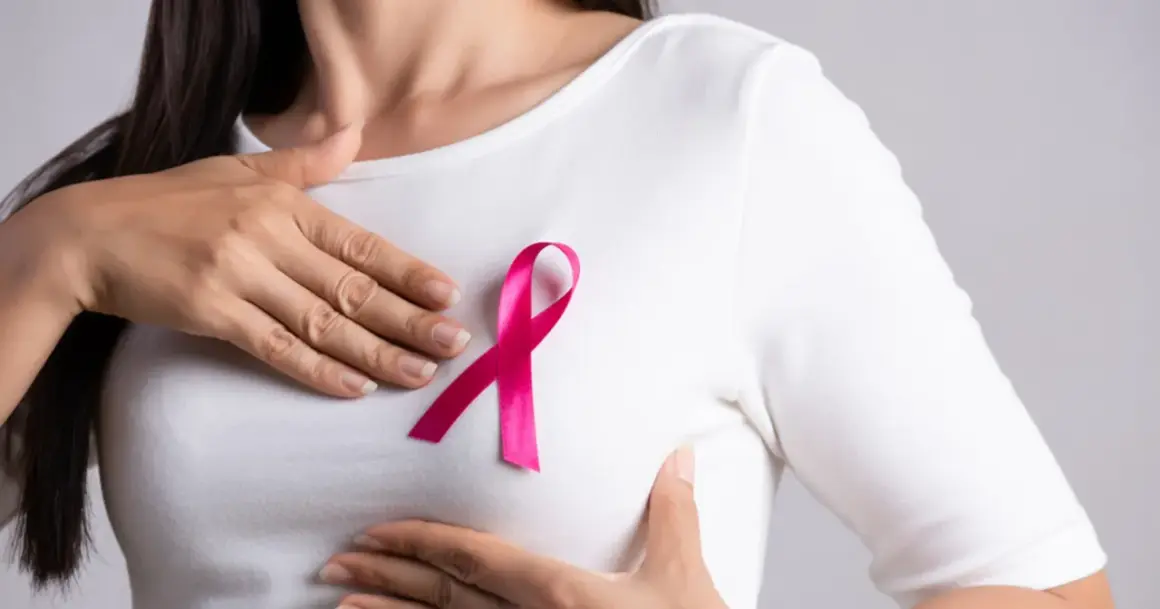 Kobieta z różową wstążką na piersi, symbolem walki z rakiem. W tle subtelne nawiązanie do leczenia, np. tamoxifen.