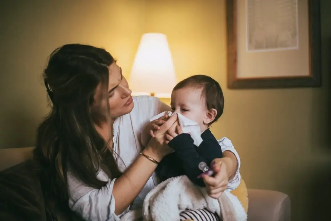 Mamma torkar sin bebis näsa med en pappersnäsduk. Små **indragningar barn** kan vara jobbiga, men mamma finns där för att trösta.