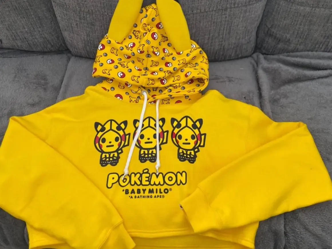 Żółta bluza z kapturem z motywem Pikachu i logiem Pokemon.