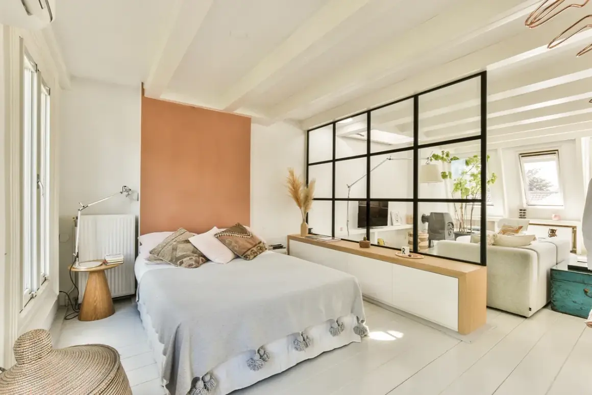 Clever 1-Zimmer-Wohnung: Das Bett wird durch eine Glaswand vom Wohnbereich abgetrennt.
