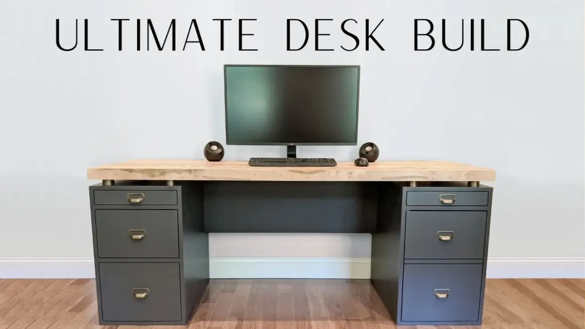 A modern DIY computer desk with a light wood top, dark gray drawers, and a monitor setup.