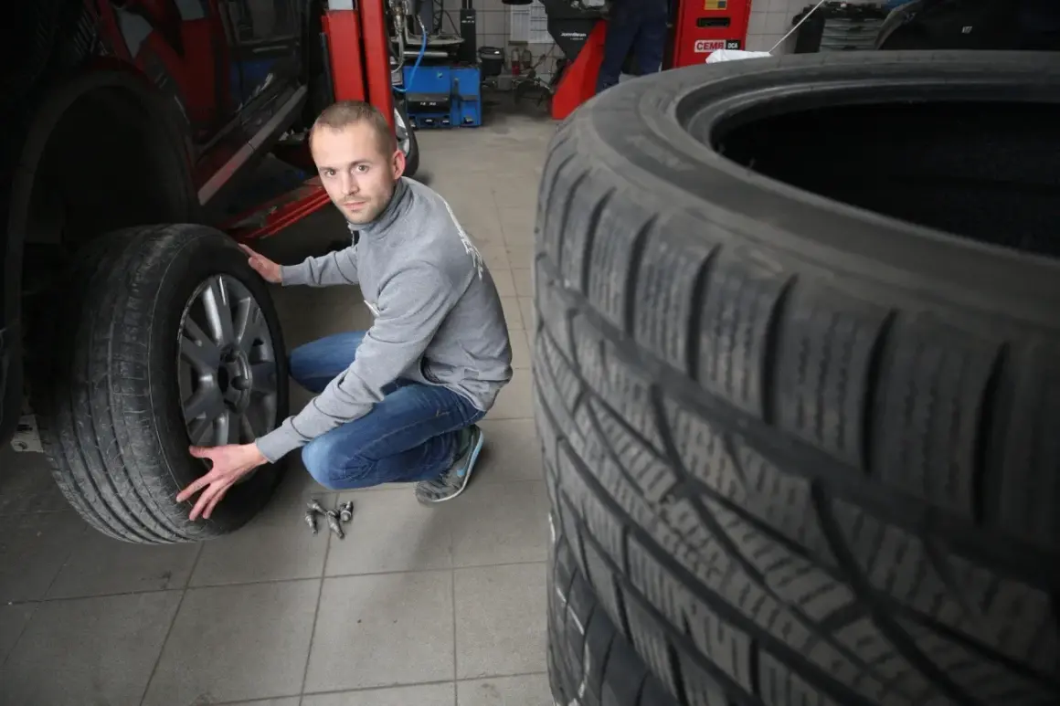 Mechanik sprawdza opony wielosezonowe, szukając najlepszych opinii przed sezonem.