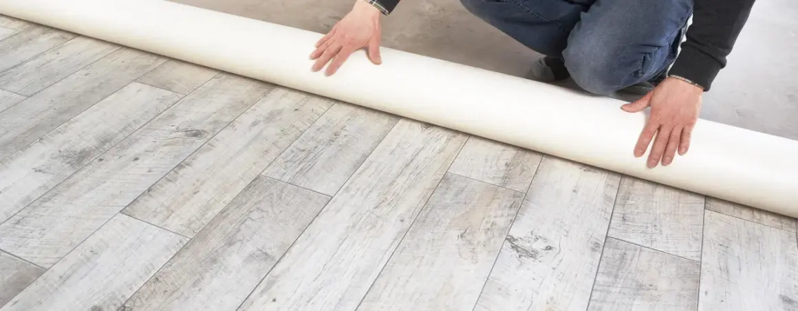 Eine Rolle Unterlage liegt auf einem Holzboden. Sie ist ideal, wenn Sie sich fragen, was kommt unter PVC Boden.