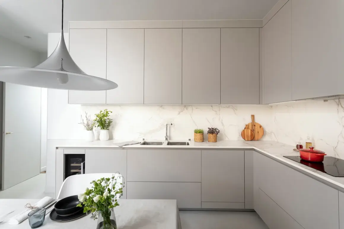 Cuisine moderne avec des meubles hauts gris épurés. La hauteur des meubles hauts cuisine est optimisée pour un rangement maximal.
