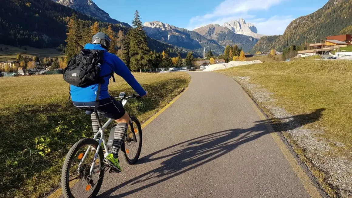 Ciclista su una strada panoramica tra le montagne del Trentino, godendosi le ciclabili.
