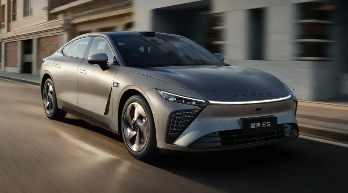 Srebrny sedan Exlantix ES pędzi ulicą, jego futurystyczny design przyciąga wzrok.